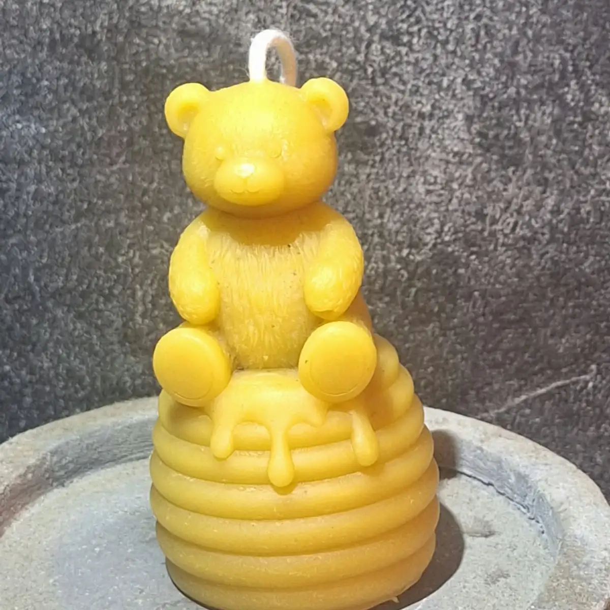 Bougie ourson assis sur un pot de miel